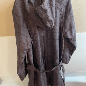 Brown trench coat with unique buttons.